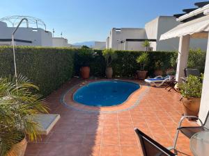 a backyard with a swimming pool and plants at Casa la Vida - Golf villa with private pool in Alhama de Murcia