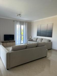 a living room with a couch and a tv at Tasos Cozy House 1 in Lefkada