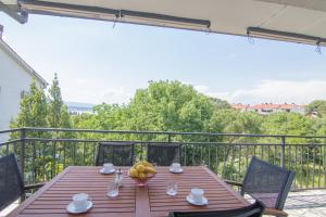 einen Holztisch mit einer Schale Obst auf dem Balkon in der Unterkunft Apartment Dina in Malinska