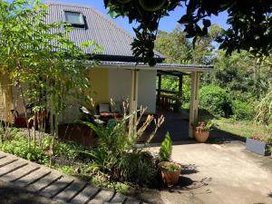a garden with a house with a patio at L’îlet Songes in Cilaos +6 photos