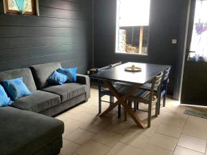 a living room with a table and a couch at L’îlet Songes in Cilaos