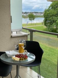 a table with a plate of food and glasses of orange juice at Relax and Spa - DeLux Apartman in Velence