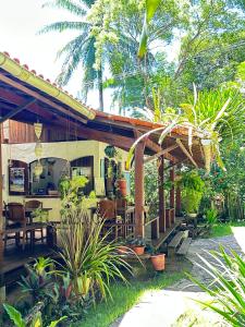 a house with a wooden pergola and some plants at Pousada Horizonte Azul in Ilha de Boipeba
