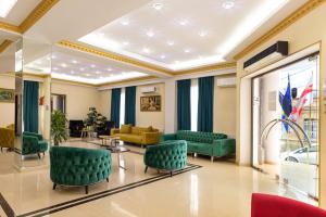 a waiting room with green chairs and tables at Hotel Grand Palace in Tbilisi City