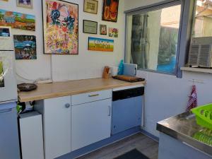 a kitchen with white cabinets and a wooden counter top at Chambre meublée indépendante, avec piscine et jardin, 1 lit pour 2 personnes in Toulouse