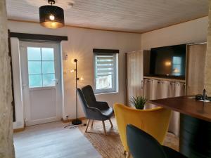 a living room with a table and chairs and a television at Love Room avec spa in Nérac