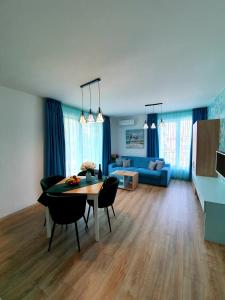 a living room with a table and a blue couch at Old Sailor Apartment in Obzor