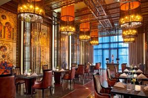 a dining room with tables and chairs and chandeliers at Sheraton Qingyuan Lion Lake Resort in Qingyuan