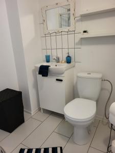 a white bathroom with a toilet and a sink at JOREDA apartamentai in Biržai