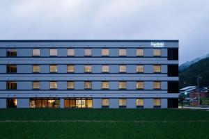 a tall building with windows and grass in front of it at Fairfield by Marriott Gifu Takayama Shirakawa Go in Takayama