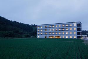 un edificio con un campo delante de él en Fairfield by Marriott Gifu Takayama Shirakawa Go en Takayama