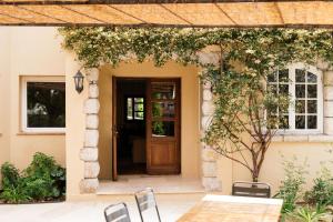 a door to a house with a table and chairs at Auberge du Rédier - Logis Hôtels in Colomars