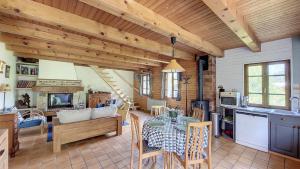 Chalet Jumbaz في Seytroux: مطبخ وغرفة معيشة مع طاولة وكراسي