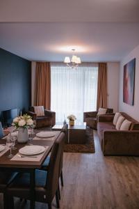 a living room with a table and a couch at Silver Mountain Resort & Spa in Poiana Brasov