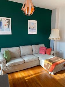 un sofá en una sala de estar con una pared verde en Altbauwohnung mit viel Charme in zentraler Lage en Kiel