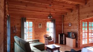 a living room in a log cabin with a couch and a tv at casa entre praias in Foz do Arelho