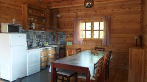 eine Küche mit einem Tisch und einem weißen Kühlschrank in der Unterkunft casa entre praias in Foz do Arelho