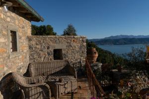 una casa de piedra con 2 sillas de mimbre en un porche en La Casa sopra il Castello - Portovenere, en Portovenere