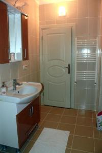 a bathroom with a sink and a shower with a door at Star apartments in Trabzon