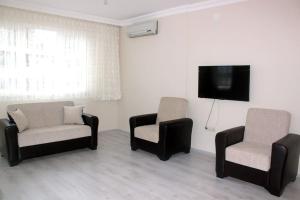 a living room with two chairs and a flat screen tv at Star apartments in Trabzon