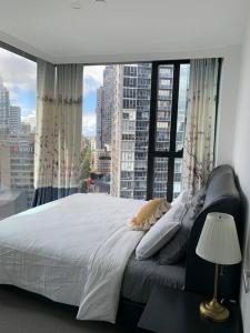 a large bed in a room with a large window at CBD Spacious Two Bedrooms Apartment in Melbourne