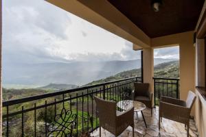a balcony with chairs and a table and a view at Ostro&scaron;ke grede in Nik&scaron;ić