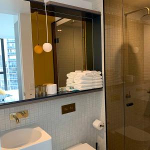 a bathroom with a shower and a sink and a mirror at CBD Spacious Two Bedrooms Apartment in Melbourne