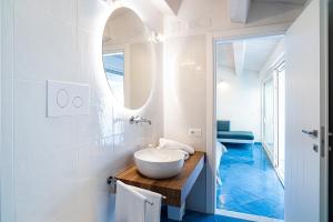 Baño blanco con lavabo y espejo en Racconti dal Mare en Santa Maria di Castellabate