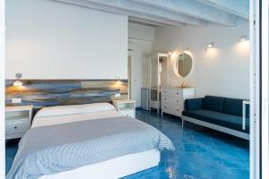 1 dormitorio con 1 cama y 1 sofá azul en Racconti dal Mare en Santa Maria di Castellabate