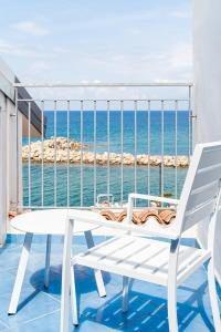 una mesa blanca y sillas en un balcón con vistas al océano en Racconti dal Mare en Santa Maria di Castellabate