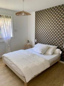 Un dormitorio con una gran cama blanca y una ventana en REZ DE JARDIN AU COEUR DES PYRENEES, en Agos-Vidalos