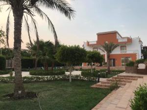 dom z palmami przed dziedzińcem w obiekcie Moubark 6 Villa 1 w mieście Hurghada