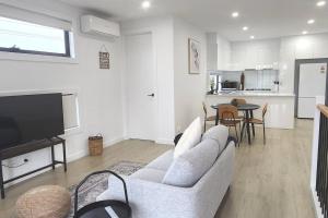 a living room with a couch and a tv and a table at Sunshine Harmony Retreat (1A) in Sunshine