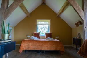 a bedroom with a large bed in a attic at TweeZeven in Guelle