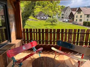 um alpendre com duas pranchas de surf, uma mesa e uma janela em Le grenier a foin em Breitenbach-Haut-Rhin