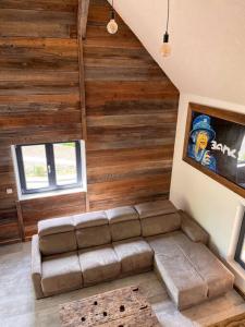 uma sala de estar com um sofá num quarto com paredes de madeira em Le grenier a foin em Breitenbach-Haut-Rhin