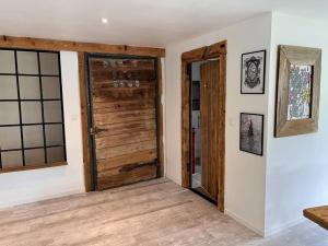 an empty room with a wooden door and windows at Le grenier a foin in Breitenbach-Haut-Rhin