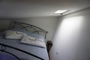 1 cama con 2 almohadas en una habitación en SAILA appartamento MARTE, en Attigliano