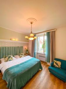 a bedroom with a large bed and a blue couch at Wellness Pension Ametyst in Český Krumlov