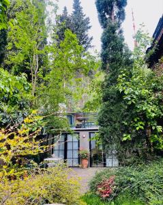 a house in the middle of a garden at Funicular Inn Apartments in Tbilisi City