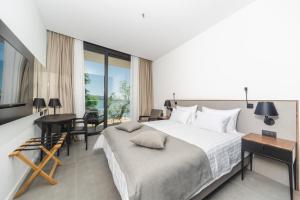 a bedroom with a bed and a table and a desk at Boutique Hotel Shell in Budva