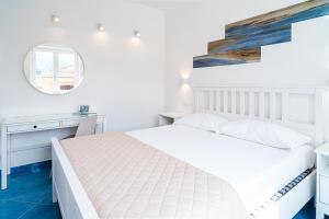 een slaapkamer met een wit bed en een bureau bij Un Posto al Mare in Santa Maria di Castellabate