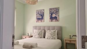 um quarto com uma cama com três pinturas na parede em Afonso Galo Guest Apartments III em Almada