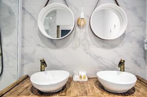 a bathroom with two sinks and mirrors on a counter at Charmant appartement avec extérieur privatif in Sète +13 photos