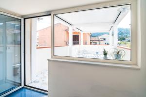a large window in a house with a view of a balcony at Un Posto al Mare in Santa Maria di Castellabate