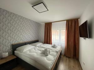 Schlafzimmer mit einem Bett mit weißer Bettwäsche und einem Fenster in der Unterkunft Cédrus Apartman in Balatonfüred