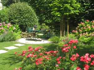 a garden with a table and pink flowers at Hotel Jäger - family tradition since 1911 in Vienna