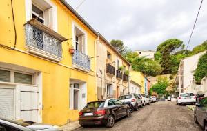 a row of cars parked on a street next to buildings at Charmant appartement avec extérieur privatif in Sète