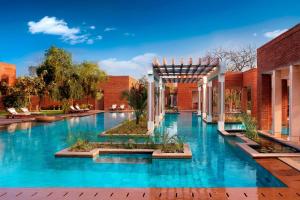 a swimming pool in a building with blue water at ITC Mughal, A Luxury Collection Resort & Spa, Agra in Agra