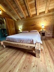 - une chambre avec un lit dans une cabane en rondins dans l'établissement LA PIANA DAL SAS, à Gravellona Toce